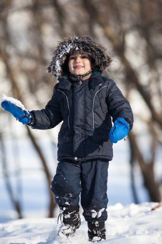 toddler playing outside in snow showing how to dress a toddler for winter